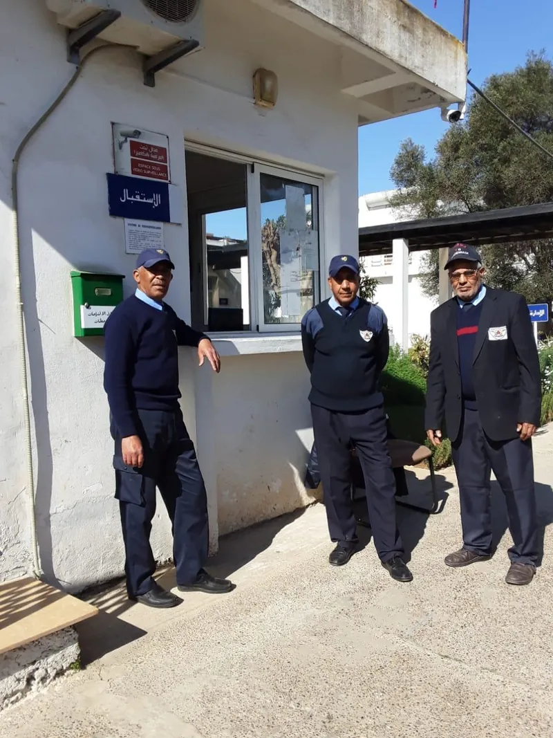 Trois agents TIHAMA devant un poste de garde.